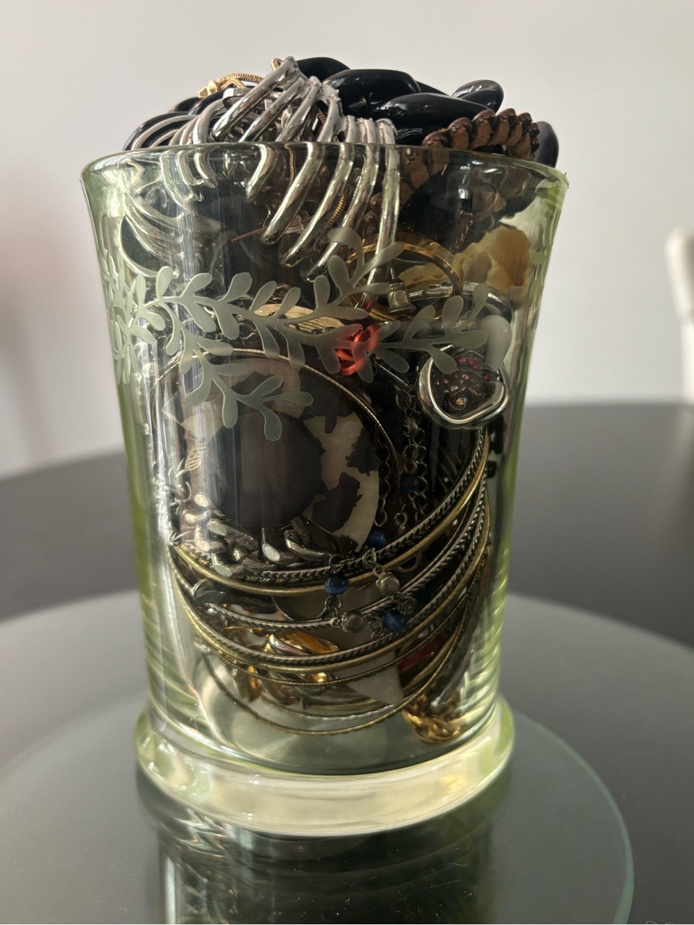 Mixed metals and black mystery jewelry jar in a cute green glass jar